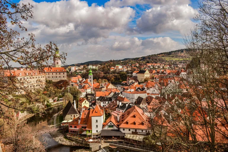 Pogled na Češki Krumlov kroz jesenje drveće