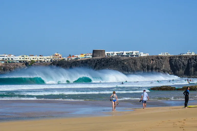 Talasi i surferi na plaži kod El Cotilla