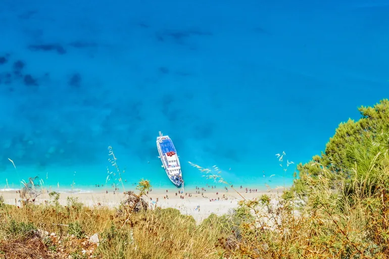 Čamac u tirkiznoj vodi kod plaže Egremni