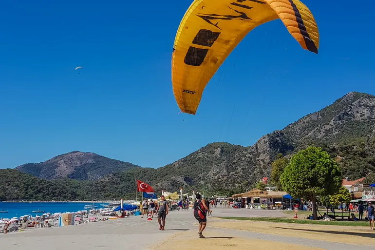 Paraglajder sleće na šetalište uz plažu